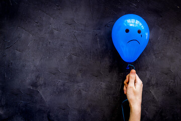 Sadness emotion face on balloon - depression mood background. Top view, copy space