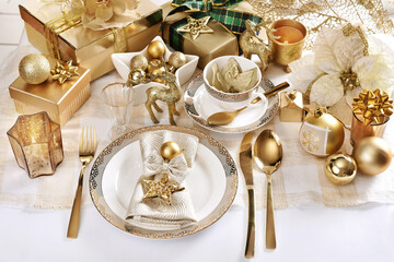 Christmas table setting in white and gold colors in glamour style