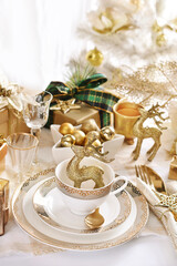 Christmas table setting in white and gold colors in glamour style