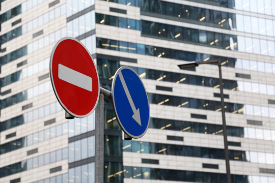 No Entry Sign And Detour Obstacles Sign On The Skyscraper Background. Concept Of Economic Sanctions, Financial Crisis