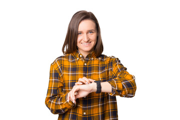 Portrait of smiling young woman looking at camera and presses a finger on the smartwatch