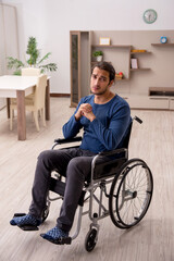Fototapeta na wymiar Young man in wheel-chair suffering at home