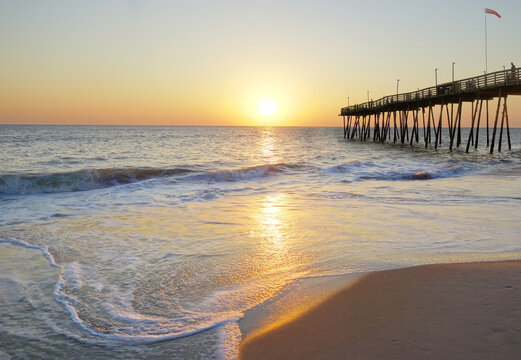 Avalon Pier and sandy beach at the Outer Banks of North Carolina at sunrise  Stock Photo