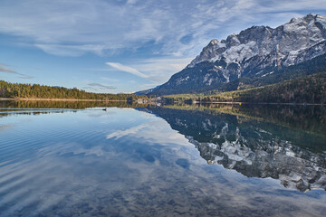 Glassy mountain lake during sunset. Reflecting mountain lake in the german alps.