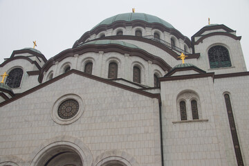 Fototapeta na wymiar Details of Saint Sava temple (Hram Svetog Save, in Serbian), windows and cupola with golden cross on top, powerful white walls. One of biggest Orthodox temples in the world, Serbia, Belgrade