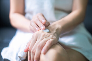 Obraz na płótnie Canvas Asia woman applying moisturizing cream/lotion on hands, beauty concept.