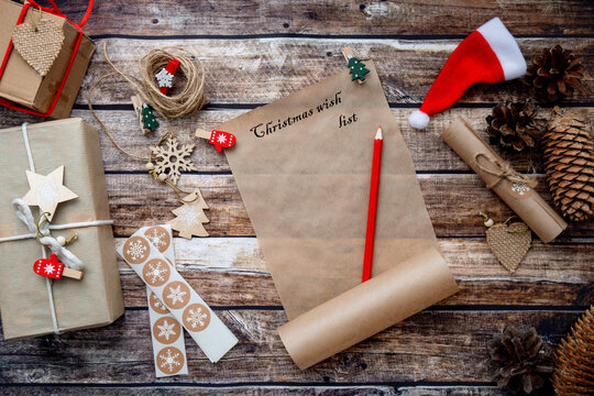 letter to santa claus, christmas wishlist on wooden background among holiday