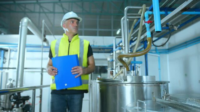 caucasian male senior engineering wearing safty uniform hand use laptop quailty control machinery checking in food processing factory industrial concept