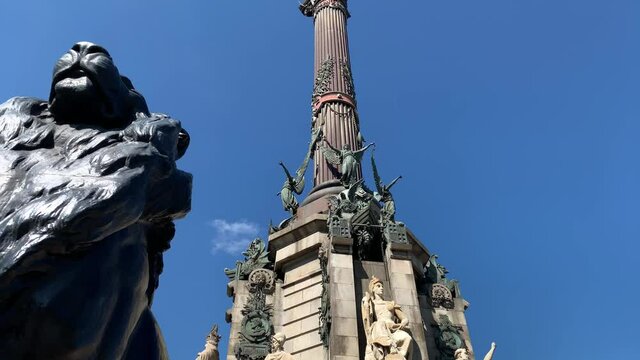 Footage of famous historical sculptures called "Mirador de Colom" in Barcelona. It is a sunny summer day. Camera moves forward.