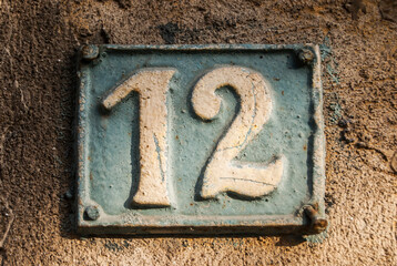 Old retro weathered cast iron plate with number 12 closeup