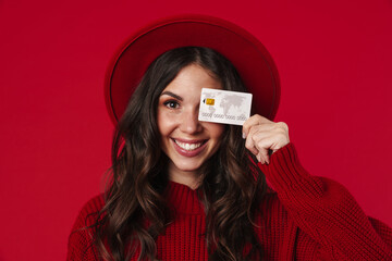 Young smiling woman wearing hat holding credit card