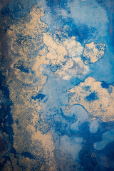 détail d'un mur peint en bleu dont la couleur s'est érodée avec le temps 