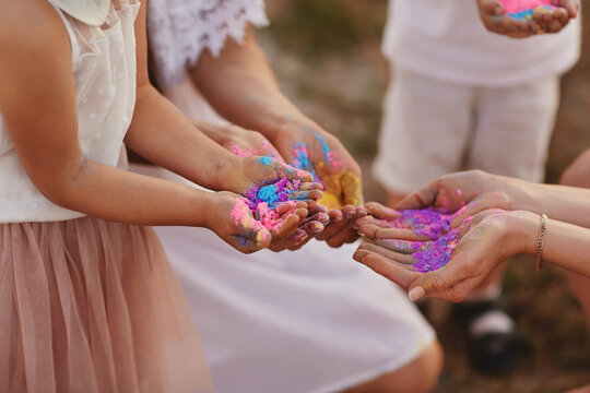hands of children and adults in the colors of the hall. family having fun with holi paints outdoors. Holi color festival