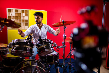 italian artist musician playing drumms during online concert at studio