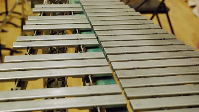 A young guy playing the vibraphone at a music school.