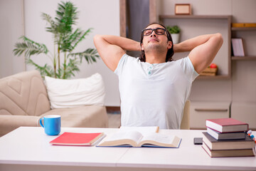 Young male student preparing for exams at home