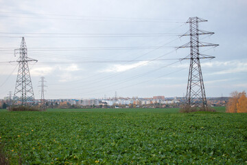 High voltage line with pylons in the field