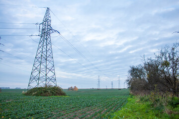High voltage line with pylons in the field