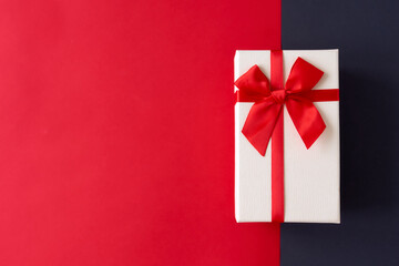 White present with red ribbon on the bright red background