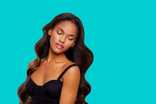 Beauty styled portrait of a young African American woman. Makeup. Fashion black girl with curly hair posing in the studio on a turquoise background. isolated. Studio shot.   