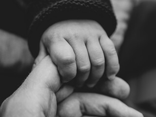 parent and child holding hand black white