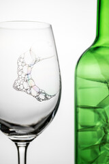 Bubbles in a glass and a green bottle
