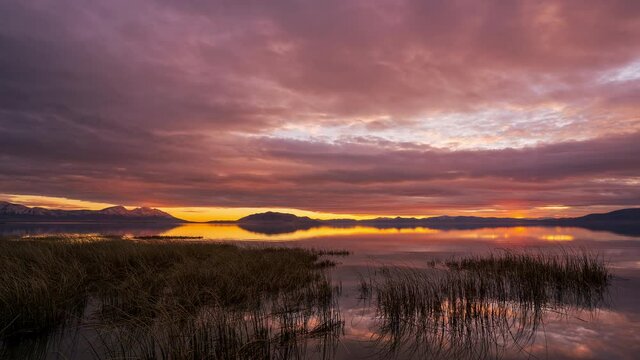 Colorful sunset timelapse over Utah Lake as the sky is on fire in beautiful landscape.