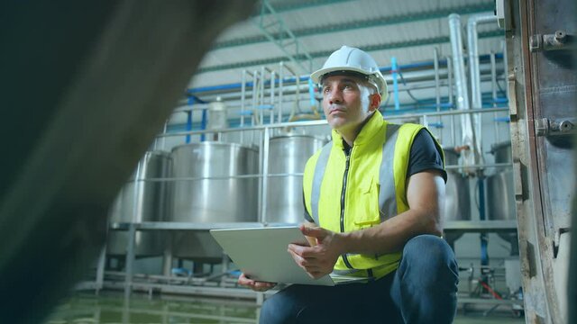 caucasian male senior engineering wearing safty uniform hand use laptop quailty control machinery checking in food processing factory industrial concept