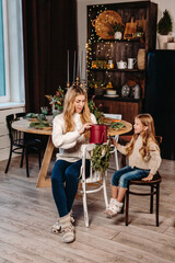 Happy mother and daughter opening presents on Christmas background at home