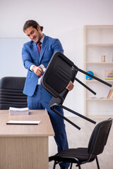 Young male employee sitting in the office in front of whiteboard