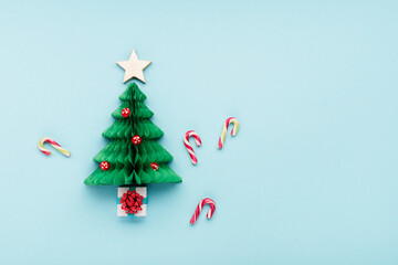 Christmas card - Xmas paper green tree, mushrooms and candy canes on blue background.