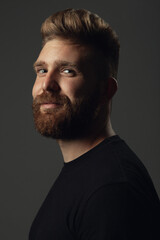 Fabulous at any age. Portrait of smiling 35-year-old man posing over gray background in black t-shirt. Close up. Hipster style. Red hair, modern haircut. Studio shot