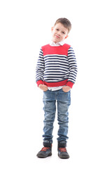 Smiling young cute boy child with hands in pockets looking at camera. Full body portrait isolated on white background. 