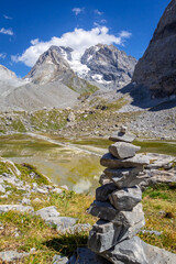 Cairn in front of the Cow lake, Lac des Vaches, in Vanoise national Park, France