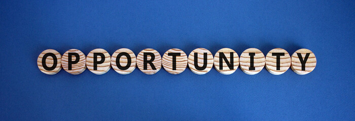 Time to opportunity. Wooden circles with the word 'opportunity'. Beautiful blue background, copy space. Business and opportunity concept.