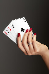 Four aces playing cards in woman's hand. Player with poker quads combination. Elegant female hands...