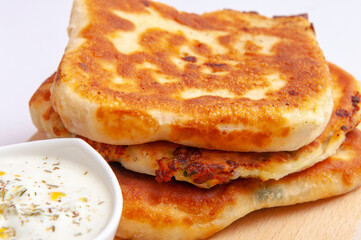 Three crunchy pies and white sauce as a stack