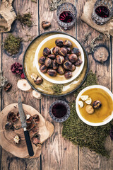 Roasted chestnuts for Christmas served on a wooden table with red mulled wine