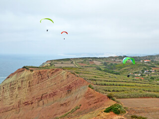 Fototapeta na wymiar Paragliders flying at Gralha, Portugal 
