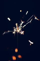 Obraz premium Sparkler overlay against black background. Festive, new years eve image. 