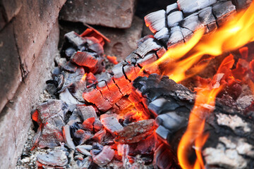 Glowing embers in hot red color, abstract background. The hot embers of burning wood log fire....