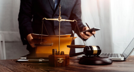 Justice and law concept.Male judge in a courtroom with the gavel, working with, computer and...