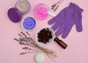Spa natural skin care. Cosmetic products - cream, oil, sea salt and soap on a pink background. View from above