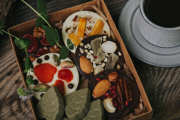Chocolates with dried fruits in a craft box and a cup of espresso coffee.