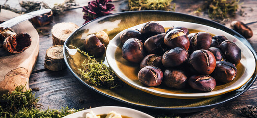 Roasted chestnuts for Christmas served on a wooden table with red mulled wine