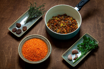 Cooking red lentil and dried apricot soup. Ingredients on plates and pan.