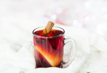 Cup of hot winter drink with knitted sweater on the table, closeup