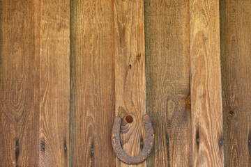 A rusty horseshoe hanging on a wood wall