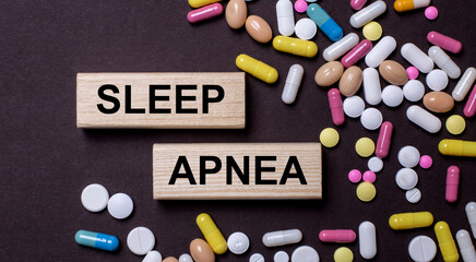 SLEEP APNEA is written on wooden blocks near multi-colored pills. Medical concept