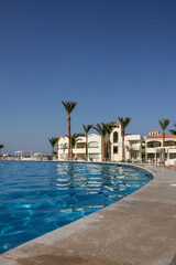 Fototapeta na wymiar Blue pool. Vacation. Vacation. Many palm trees and hotels. Sea vacation.
